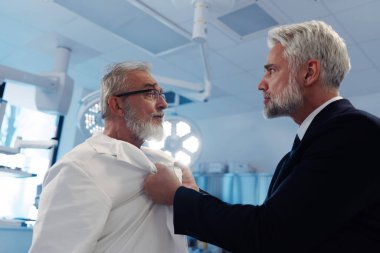 Sağlık çalışanlarına karşı şiddet. Hasta agresif, doktorla kavga ediyor, onu ceketinden tutuyor..