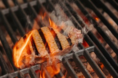 Izgarada açık ateşte sulu bir New York bifteği kızartıyorum..