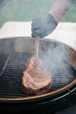 Izgarada lezzetli bir Tomahawk bifteği kızartıyorum..