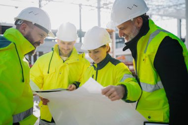 Mühendisler ve inşaat işçileri modern inşaat alanındaki gelişmeleri inceliyor..