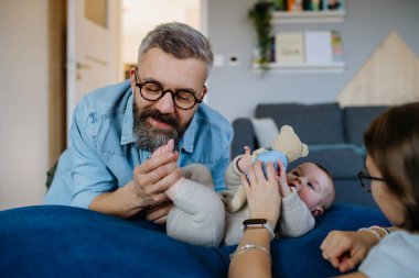 Ablam ve babam yeni doğan bebeğe bakıyor. Babalar Günü konsepti.