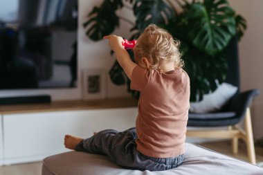 Sevimli çocuk kapatılmış bir video oyun konsoluyla oynuyor.