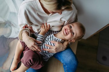 Güzel anne, küçük oğluna sarılıyor..