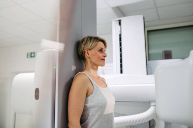 Dinamik X-ray taramasından geçen kadın hasta eğimli floroskopi duvarı ünitesi, duvar destekli radyografik tablo kullanıyor..