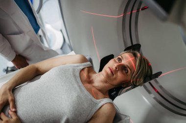 Hasta beyin taraması için bilgisayarlı tomografiye yerleştirildi. Kırmızı lazer çizgileri.