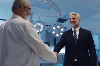 İlaç satış temsilcisinin portresi doktorla tokalaşıyor. Hastane müdürü, özel sağlık kliniği müdürü..