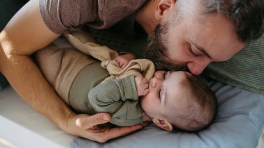 Baba bebeği uyutur, başını öper ve sakinleştirir..