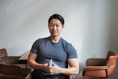 Kameraya bakan kaslı Asyalı genç bir adamın portresi..