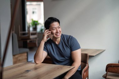 Kafe masasında kendine güveni tam bir delikanlının telefonu var..