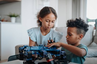 Çocuklar evde drone ile oynuyorlar. Çocuklar için eğitici robotik kitler.