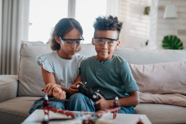 Çocuklar evde drone ile oynuyorlar. Çocuklar için eğitici robotik kitler.