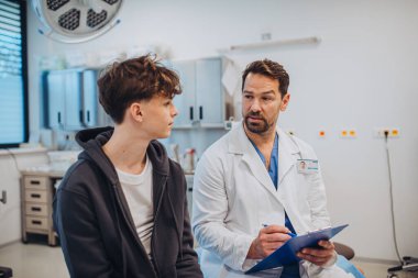 Ruh sağlığı değerlendirme formunu dolduran doktor ve genç hastalara yakın çekim.