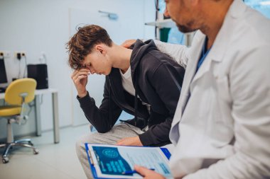 Ruh sağlığı değerlendirme formunu dolduran doktor ve genç hastalara yakın çekim.