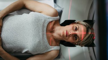 Hasta beyin taraması için bilgisayarlı tomografiye yerleştirildi. Kırmızı lazer çizgileri.