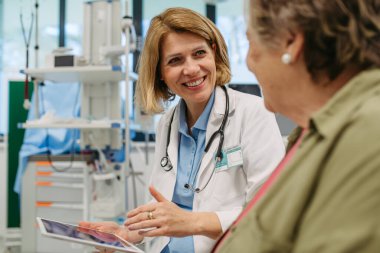 Geriatrist, muayene sırasında yaşlı bir hastayla test sonuçları hakkında konuşuyor. Tıbbi danışma.