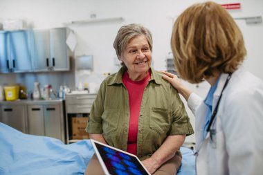 Geriatrist, muayene sırasında test sonuçlarını yaşlı hastaya açıklıyor. Tıbbi danışma.