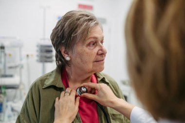 Yaşlı bir hastanın kalbi yaşlı bir doktor tarafından kontrol ediliyor. Yaşlı kadınlar için sağlık sınavı.