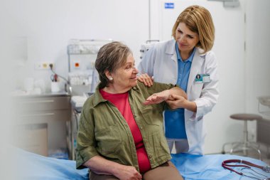 Geriatrist rutin kontroller sırasında yaşlı kadınların hareketliliğini inceliyor. Yaşlı bakımı.