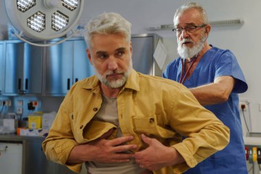 Doktor hastayı muayene ediyor, steteskopla nefes alıyor..