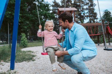 Baba küçük oğlunu sallıyor, salıncak, hafta sonu eğlencesi..
