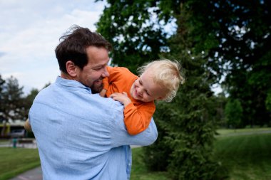 Babası, oğluyla şehir parkında oynuyordu.