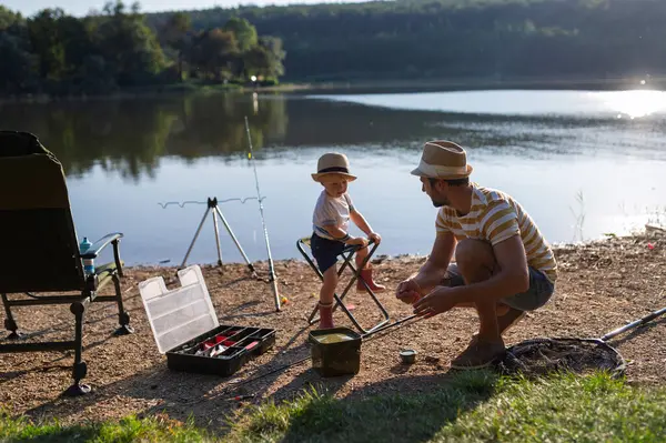 Babası küçük oğluna gölde balık tutmayı öğretiyor.