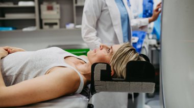 Hasta beyin taraması için bilgisayarlı tomografiye yerleştirildi. Kırmızı lazer çizgileri.