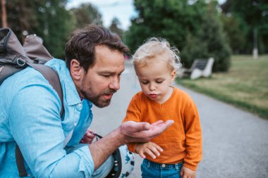 Baba ve oğul doğa yürüyüşü sırasında bir böceği gözlemliyor..