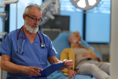 Hastanedeki muayene odasında duran yaşlı doktorun portresi..