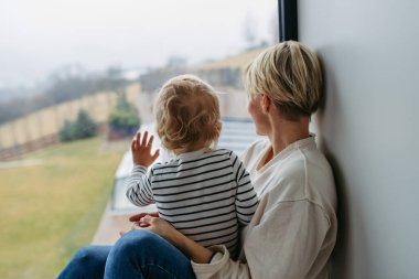 Oğlan ve anne pencereden dışarı bakıyor, doğaya hayran..
