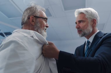 Sağlık çalışanlarına karşı şiddet. Hasta agresif, doktorla kavga ediyor, onu ceketinden tutuyor..