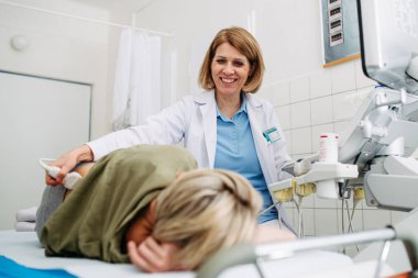 Sırtında ultrason sondası olan tıbbi muayene. Böbrek ya da pelvis ultrasonu.