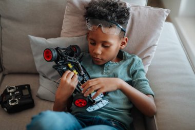 STEM öğreniminin bir parçası olarak evde robot araba üretmeye ve programlamaya odaklanmış çocuk..