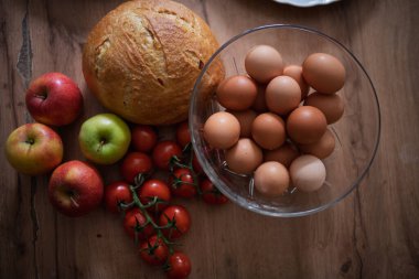 Ev yapımı kahvaltı için taze malzemeler. Kırsal masada yumurta, ekmek ve meyve..