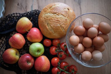 Ev yapımı kahvaltı için taze malzemeler. Kırsal masada yumurta, ekmek ve meyve..