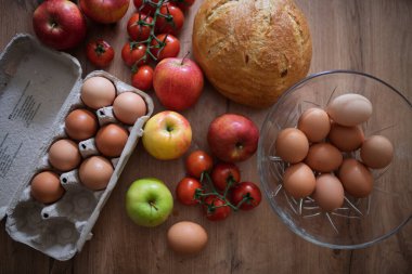 Ev yapımı kahvaltı için taze malzemeler. Kırsal masada yumurta, ekmek ve meyve..
