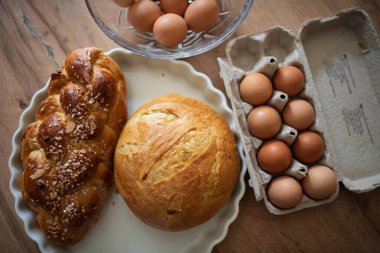 Kırsal mutfak masasında ev yapımı ekmek ve yumurta. Geleneksel kahvaltı malzemeleri.