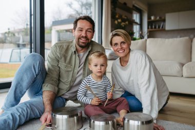 Anne babası ve küçük oğlu mutfak çanaklarında davul çalıyorlar..