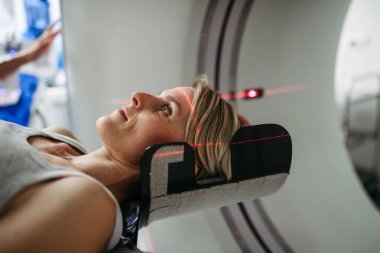 Hasta beyin taraması için bilgisayarlı tomografiye yerleştirildi. Kırmızı lazer çizgileri.