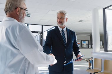 Doktorla el sıkışan müdürün portresi. Hastane müdürü, hastane ayarları..