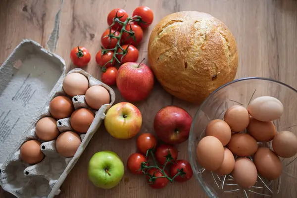 Ev yapımı kahvaltı için taze malzemeler. Kırsal masada yumurta, ekmek ve meyve..