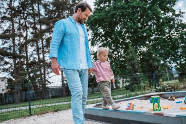 Baba ve çocuğun çocuk parkında eğlenirken portresi. Babalar Günü konsepti.