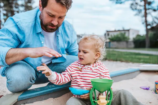 Baba ve küçük çocuk oyun parkında oynuyorlar, hafta sonu eğlencesi..
