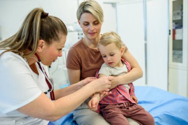 Doktor iğne yerine pamuk ve tıbbi bant yerleştiriyor. Koruyucu bakım.