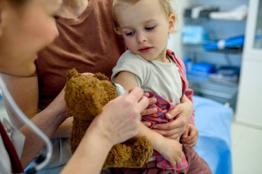 Doktor iğne yerine pamuk ve tıbbi bant yerleştiriyor. Koruyucu bakım.
