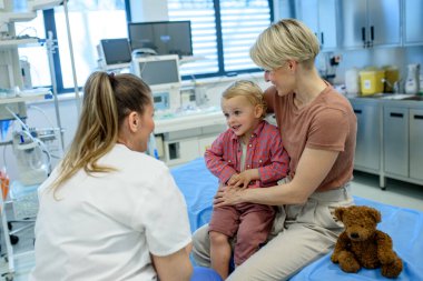 Önleyici sağlık kontrolü sırasında küçük çocuğu muayene eden kadın çocuk doktoru..