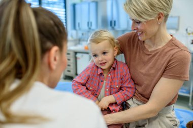 Önleyici sağlık kontrolü sırasında küçük çocuğu muayene eden kadın çocuk doktoru..