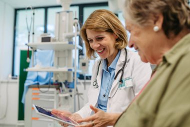 Geriatrist, muayene sırasında yaşlı bir hastayla test sonuçları hakkında konuşuyor. Tıbbi danışma.