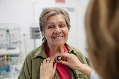 Geriatrist doktor steteskopla yaşlı hastayı muayene ediyor. Yaşlı kadınlar için rutin sağlık muayenesi.