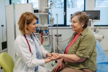 Bakıcı doktor hasta elini tutuyor, şefkatli bir jest yapıyor..